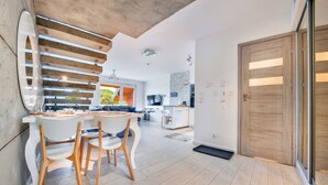 Una cocina moderna con comedor, piso de madera y un gran puerta de madera.