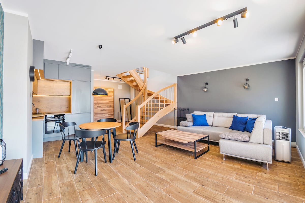 A modern living room with a sofa, coffee table, and dining area.