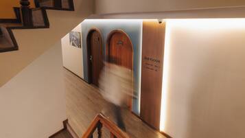 A staircase with wooden railings and a wall with doors labeled '3rd FLOOR' and room numbers.
