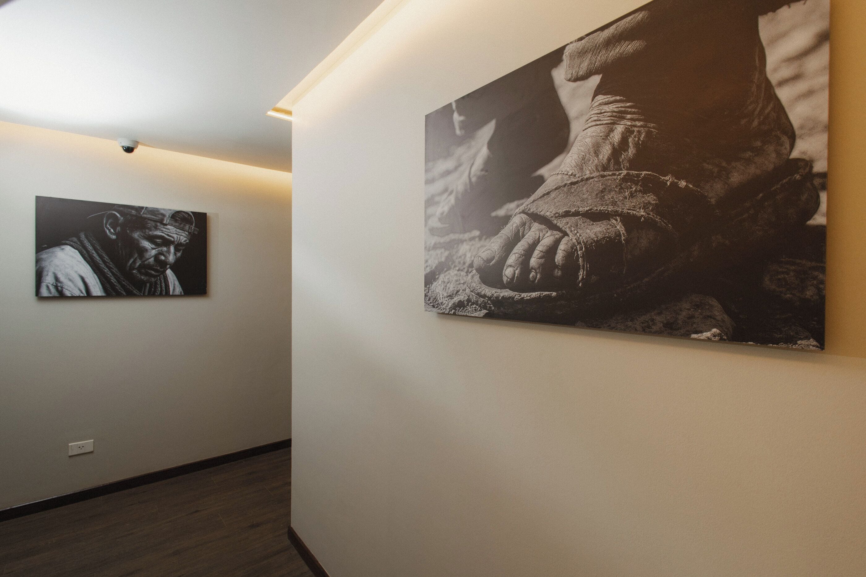 A hallway with two large black and white photographs on the walls.