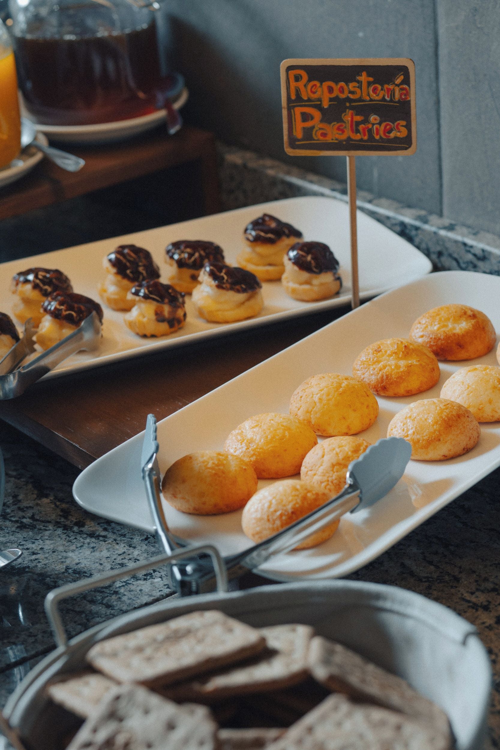 Mesa de buffet com um letreiro que diz 'Repostería Pastel de Canela' e diversos doces.