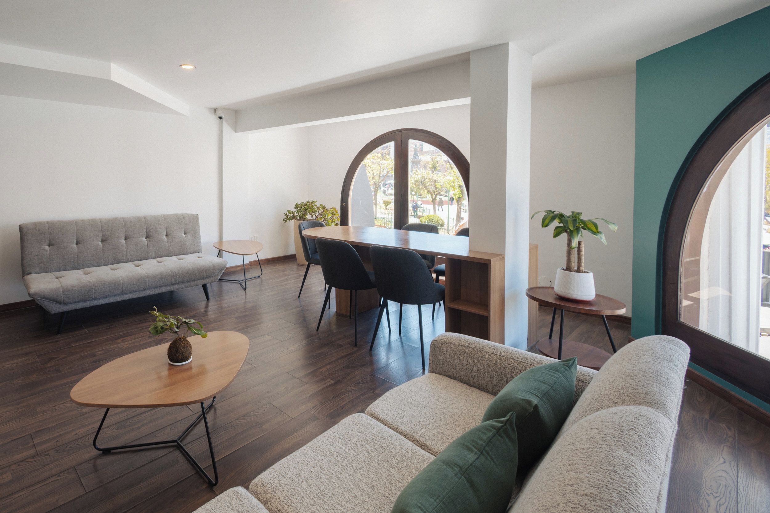 Una sala moderna con un sofá, una mesa de centro y un comedor con sillas y una mesa.