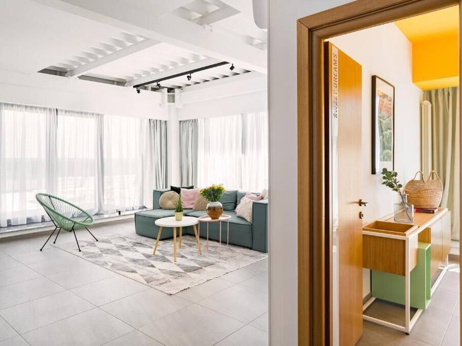 Una sala de estar moderna con un sofá, una silla, una mesita y un armario.