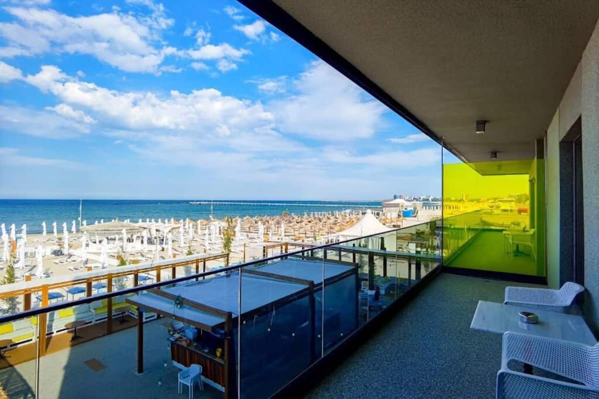 A balcony with a view of the beach and ocean.
