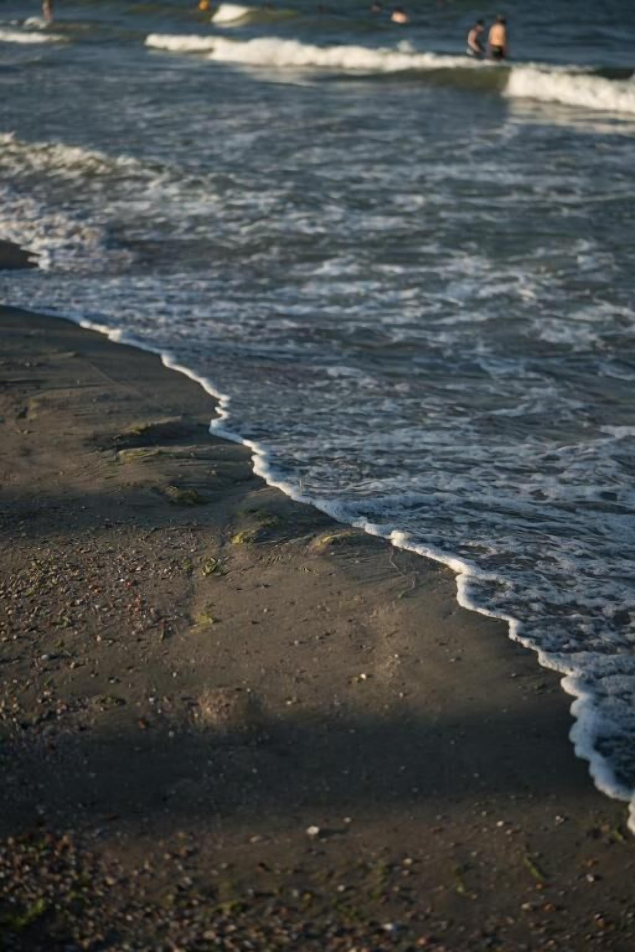 Ein Strand mit sanft brandenden Wellen.