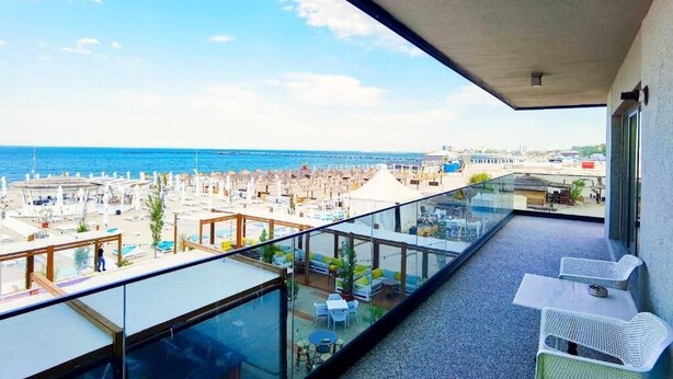 A balcony with a clear view of the beach and ocean.