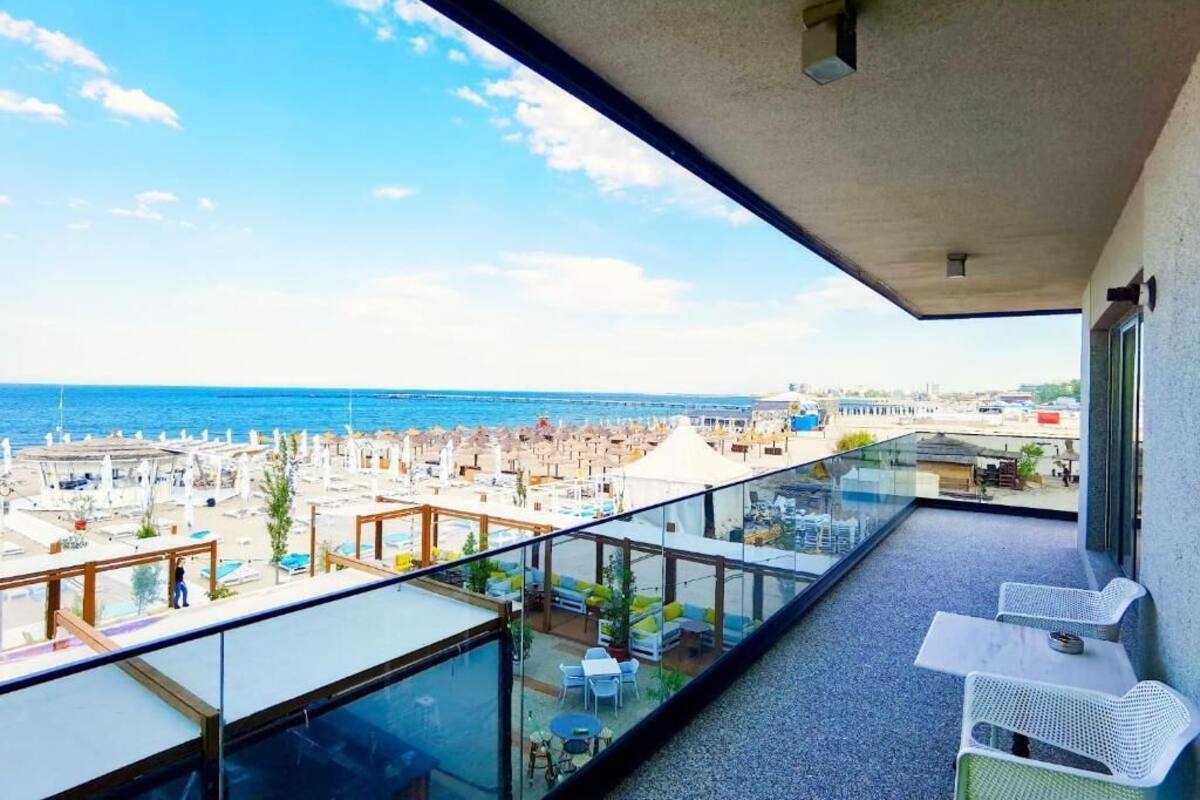 A balcony with a clear view of the beach and ocean.