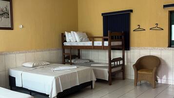 Una habitación con literas, una silla y un aire acondicionado montado en la pared.