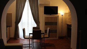 Un salón acogedor con televisor, asientos y chimenea.
