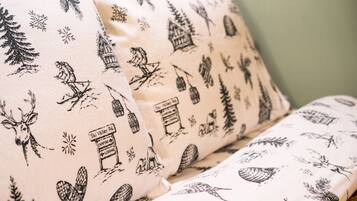 A pillow with a ski-themed pattern, including a skier, a cabin, and a mountain scene.