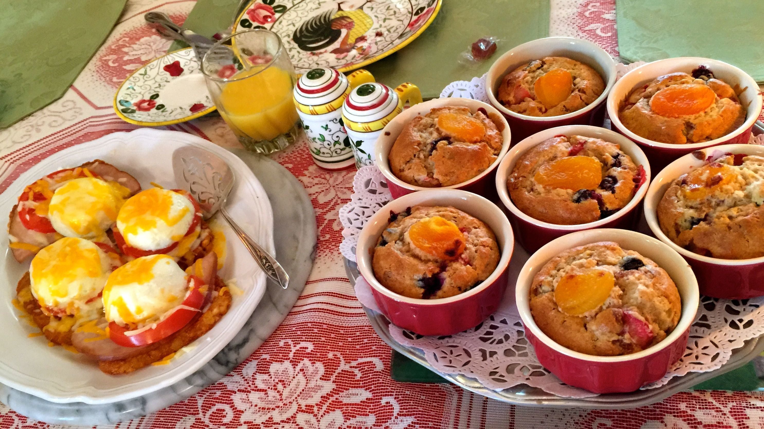 A breakfast setting with various dishes, including baked goods and a plate with eggs and cheese.