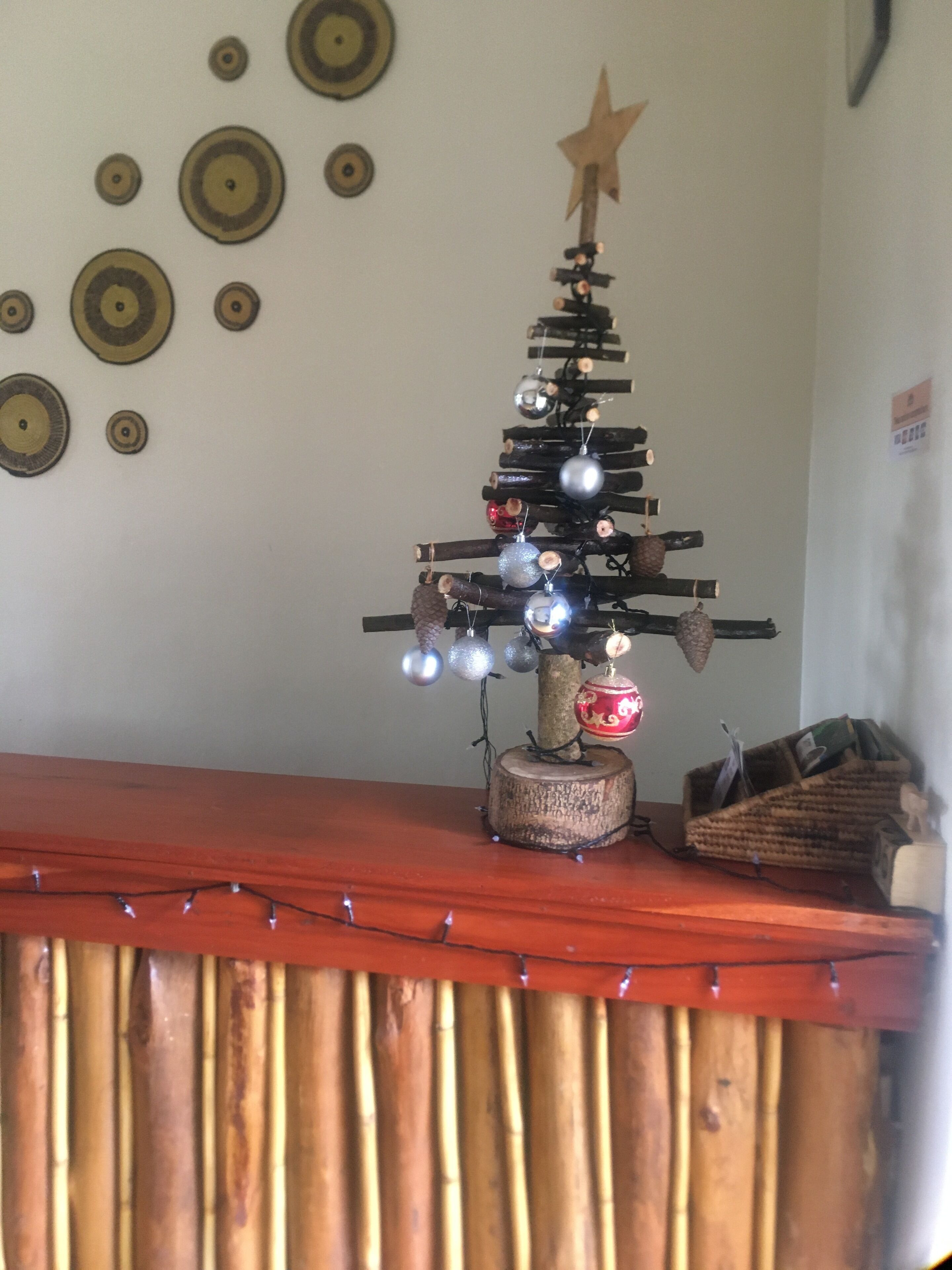 A small Christmas tree with ornaments and a star on a wooden stand.