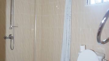 Un baño con ducha, inodoro y lavamanos.