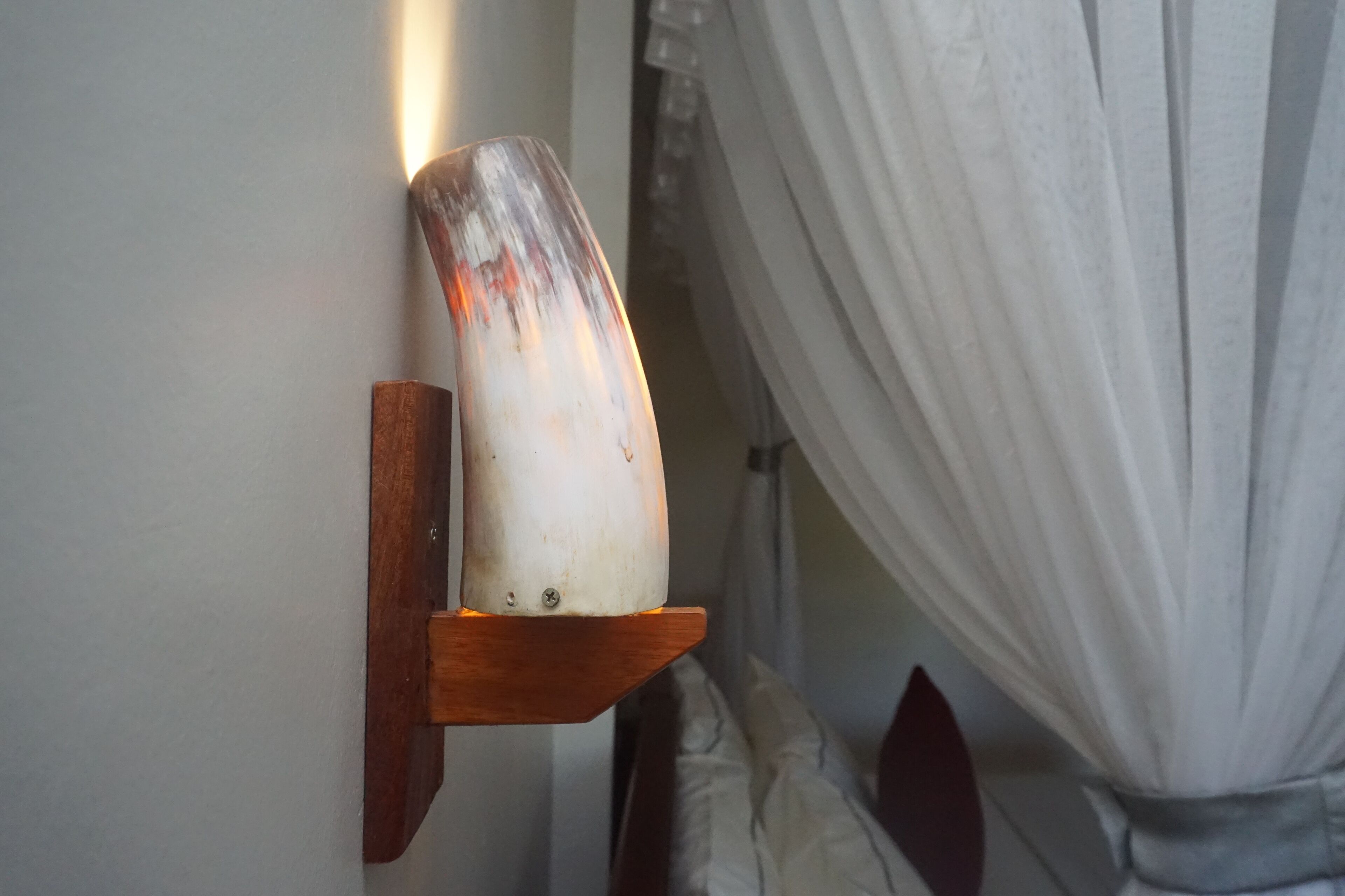 A wooden object mounted on a wall, possibly a decorative piece or a functional item.