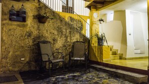 A staircase leading to a second floor with two chairs and potted plants on the landing. - Posada Antiguo Camino Real (Xalapa)