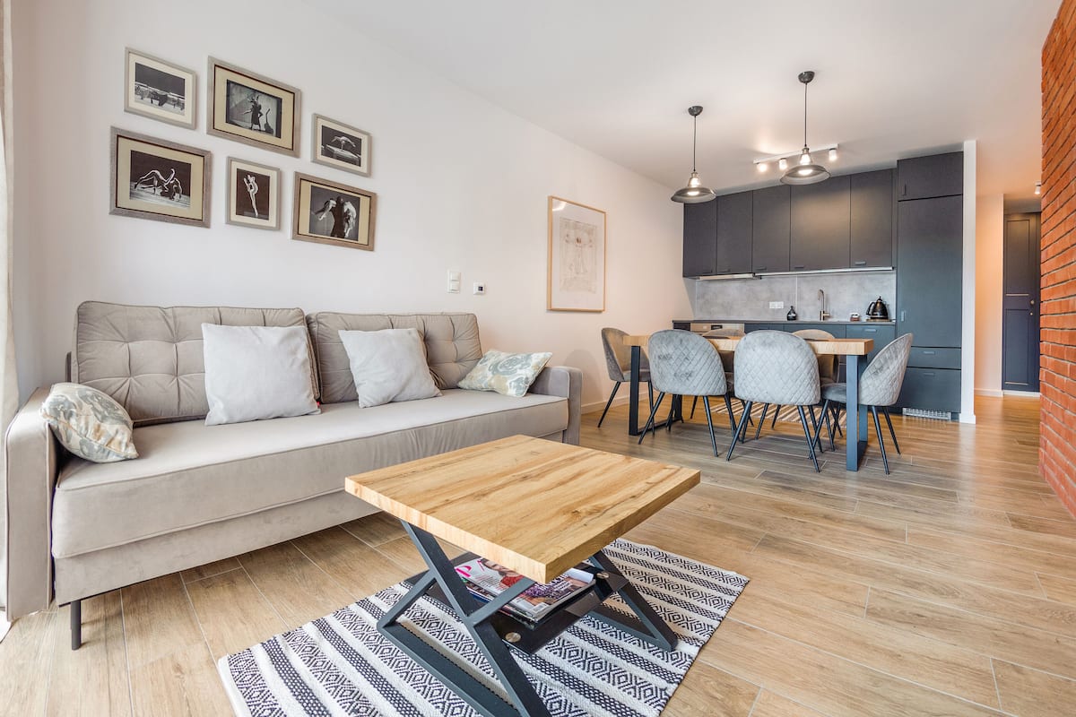 A modern living room with a sofa, coffee table, and dining area.