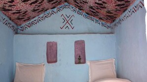 A room with two beds, each with a red and white patterned bedspread. The walls are painted light blue, and there is a decorative pattern on the ceiling. - Hostel take your time 4225 (Zagora)