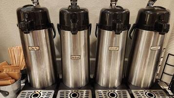 Four stainless steel water dispensers labeled 'Day's Medium' and 'Decaf' on a countertop.
