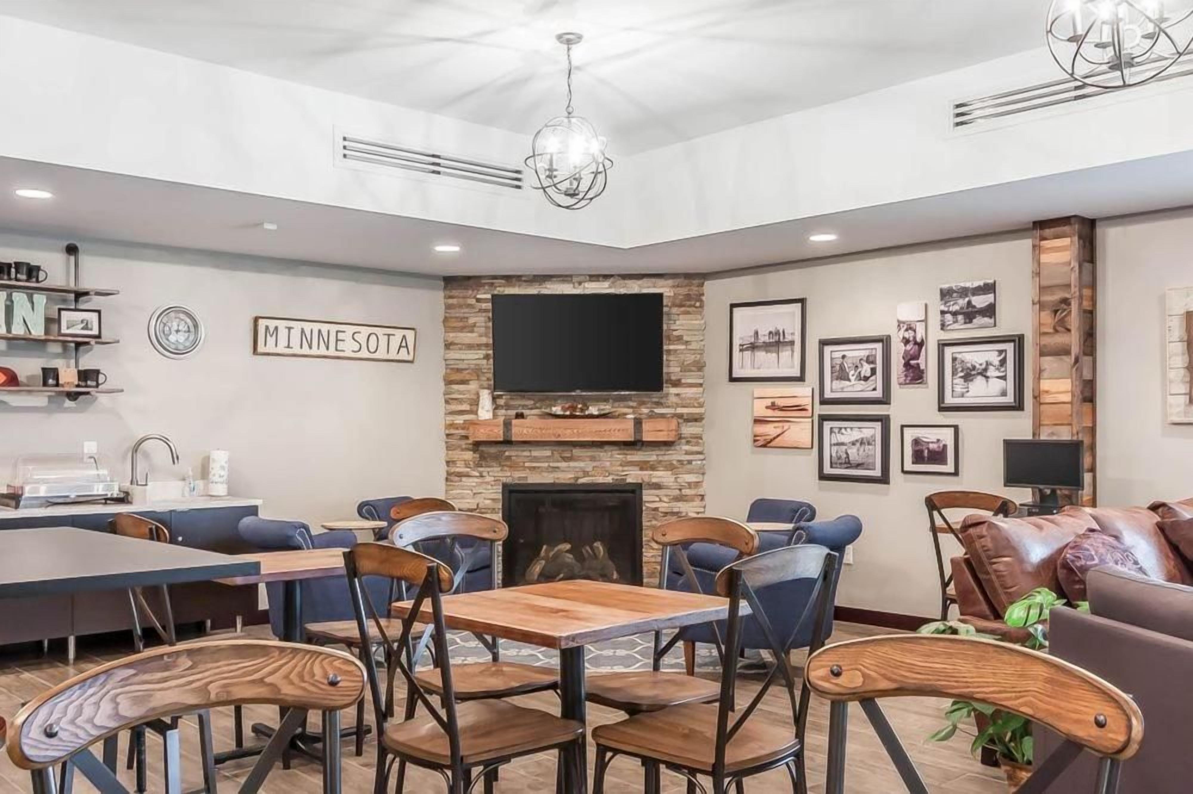 A modern living room with a fireplace, a television, and a dining area with wooden tables and chairs.
