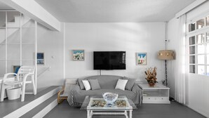 Ein modernes Wohnzimmer mit Sofa, Couchtisch und Fernseher.