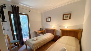 A hotel room with two single beds, a small table, a chair, and a balcony with a view. - Levantin Inn 1,2 Room N12 (Budva Municipality)