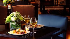 A dining table set with plates of food, glasses of wine, and a vase of flowers. - Touchstone Resort (Muskoka Lakes)