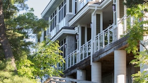 A multi-story house with a balcony, surrounded by trees. - Touchstone Resort (Muskoka Lakes)