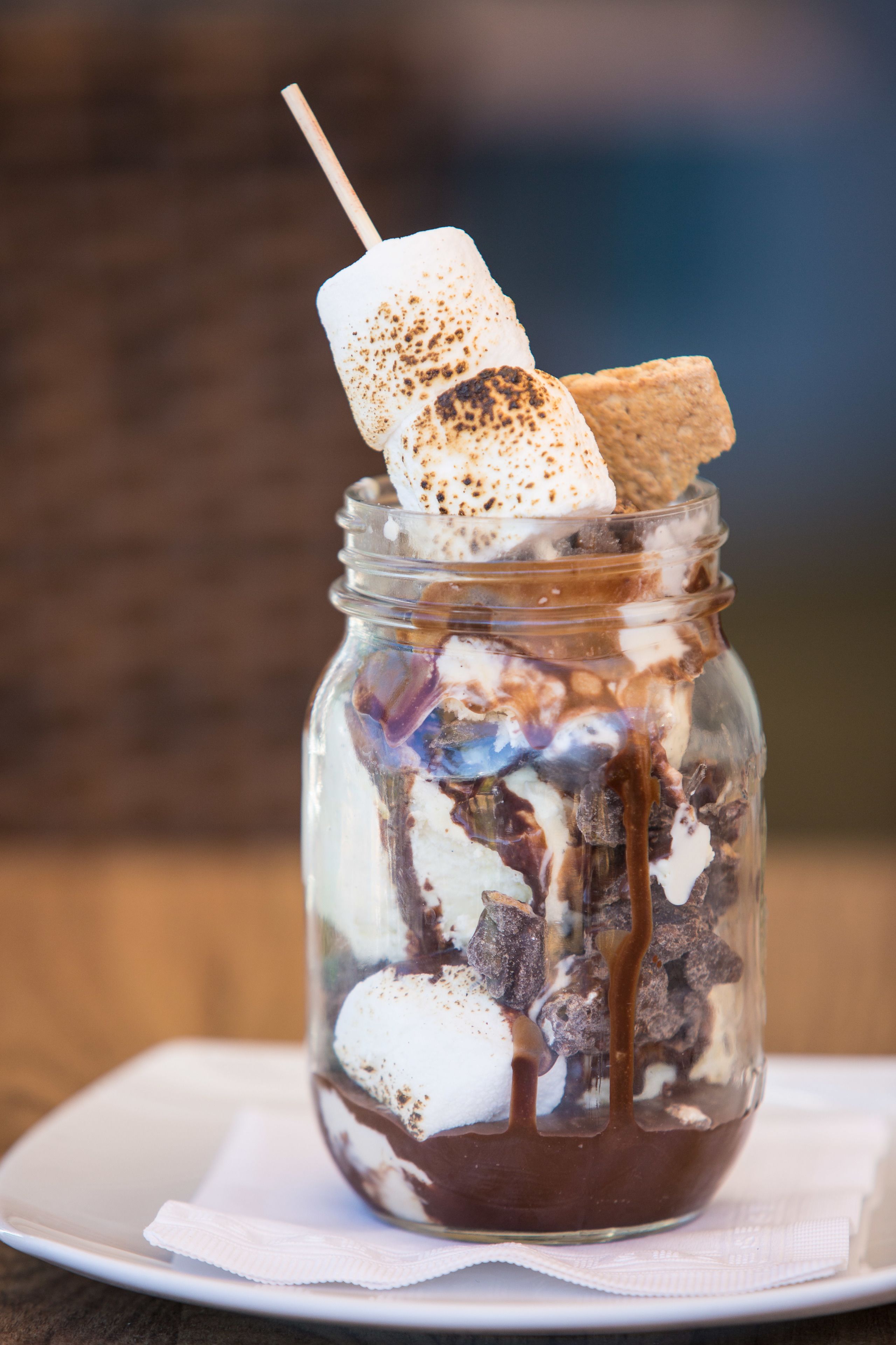 Dessert i glas med marshmallows, chokolade og en cookie.