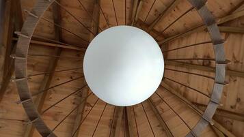 A circular wooden ceiling structure with a central white sphere.