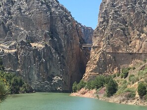 A canyon with a bridge over a river. - El Cielo Azul (Álora)