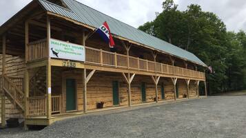 A wooden building with a balcony and a sign that reads "Halfway House Motel".