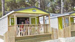 A mobile home with a wooden deck and a stone wall foundation. - Camping Interpals (Pals)