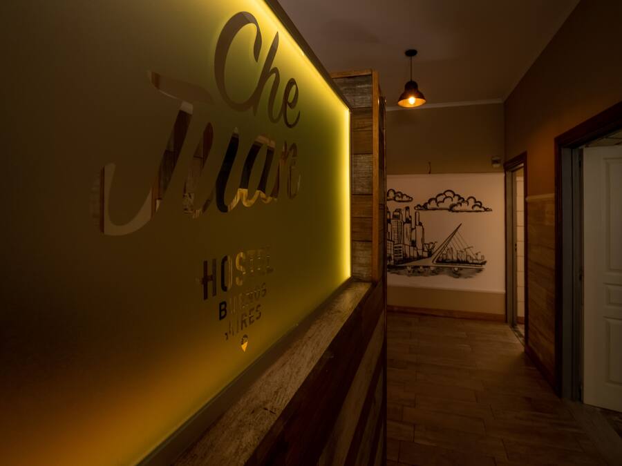 Un couloir dont un mur est décoré avec l’inscription « Che J’aime Hostel B » et une fresque représentant un paysage urbain.