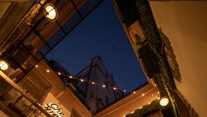 A courtyard with a restaurant named "Chez Kahn" featuring outdoor seating, a fountain, and a view of the sky. - Che Juan Hostel BA (Buenos Aires)