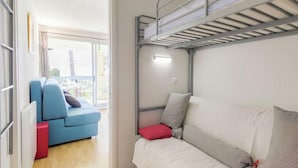 A room with a bunk bed, a sofa, and a red chair. - le Clos des Lavandes by Interhome (Bandol)