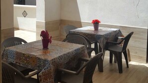 An outdoor dining area with tables and chairs, covered by a large umbrella. - B&B Stella Maris Trapani Centro (Trapani)