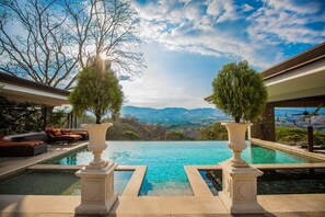 A pool with a mountain view, two large vases, and outdoor seating. - La Toscana Hills (Atenas)