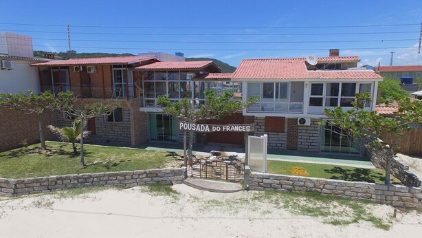 A building with a sign reading "POUSADA DO FRANCES" and a stone wall with a gate.
