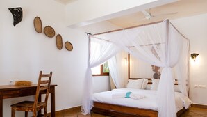 Une chambre à coucher avec un lit à baldaquin, un bureau en bois et une chaise.