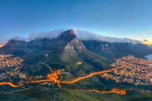 A mountainous landscape with a town nestled at its base, featuring winding roads and a prominent peak.