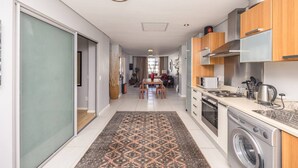 Een moderne keuken met roestvrijstalen apparatuur, houten kastjes en een centraal kookeiland.