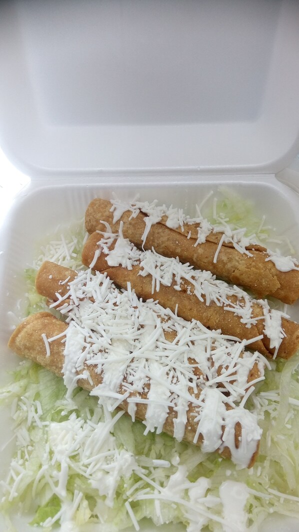 Un recipiente con alimentos fritos, queso rallado y lechuga.