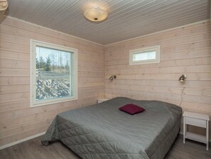 A room with a bed, a window, a wall-mounted lamp, and a ceiling light fixture. - Riemukaari by Interhome (Pertunmaa)