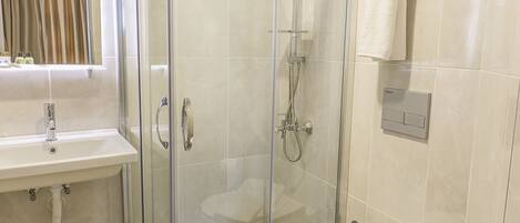 Un baño moderno con ducha envuelta en vidrio, inodoro y lavamanos.