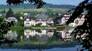 Una vista tranquilla di un lago con un villaggio europeo tradizionale, case riflesse nell'acqua.