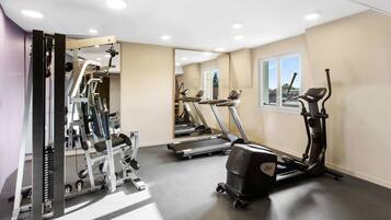 A gym with treadmills, an elliptical, and weight machines.