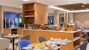 A modern breakfast area with a central bar, seating, and coffee machines. - Best Western Le Beffroi (Loos)