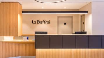 A reception desk with a wooden panel design and a black counter.