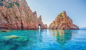 Paisaje costero con acantilados rocosos y aguas turquesas cristalinas.