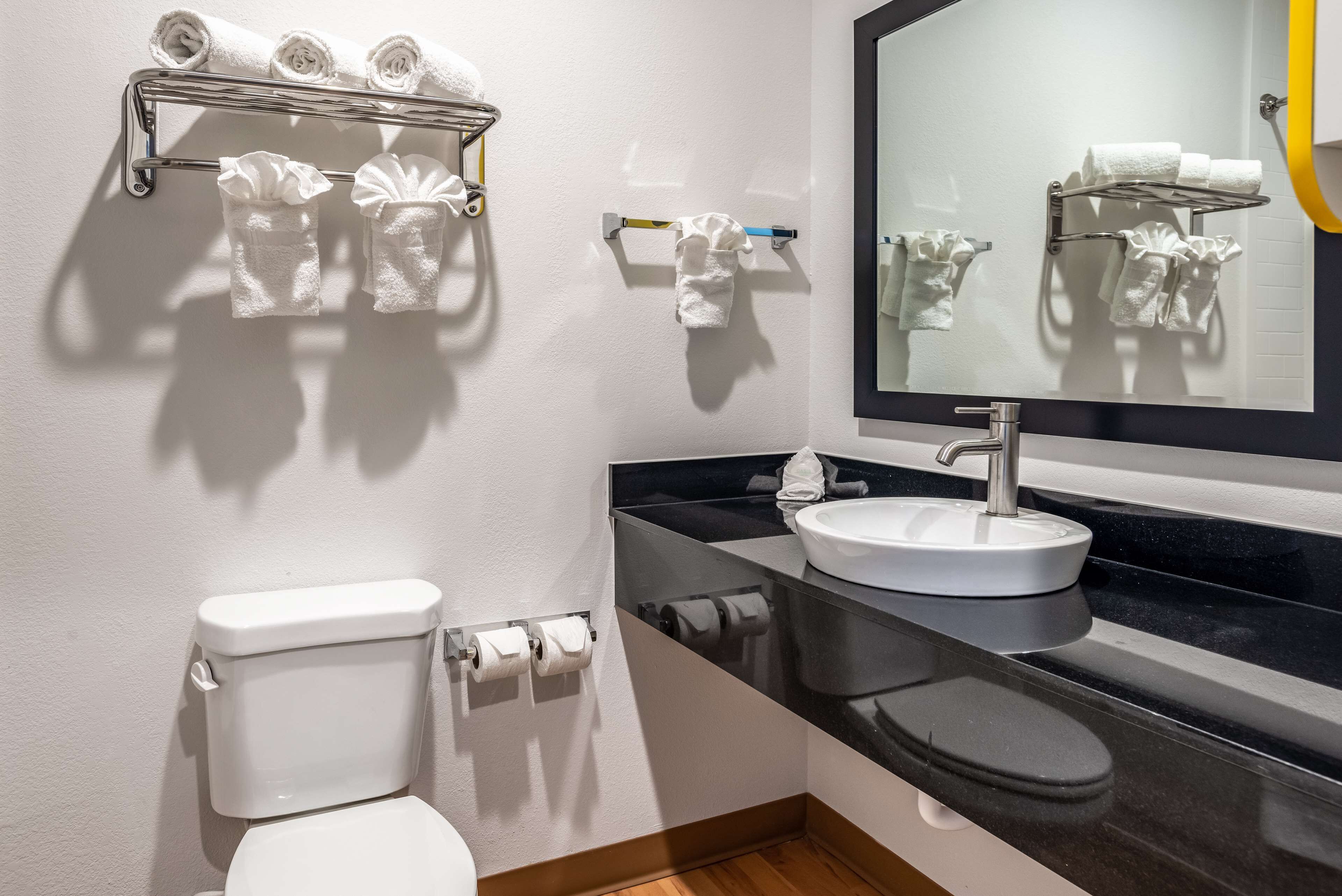 A modern bathroom with a toilet, sink, and towel rack.